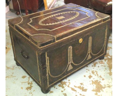 TRUNK, Regency black hide and brass studded with rising lid on later bun supports, 52cm D x 84cm W x 50cm H.