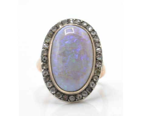 A 9ct rose gold opal and diamond ring. The ring set with&nbsp; a central opal cabochon surrounded by rose cut diamonds having