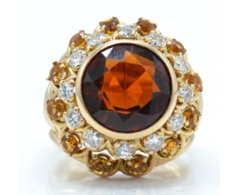 A French 18ct gold citrine and diamond sunflower ring. The ring set with a large round mixed cut citrine surrounded by a halo