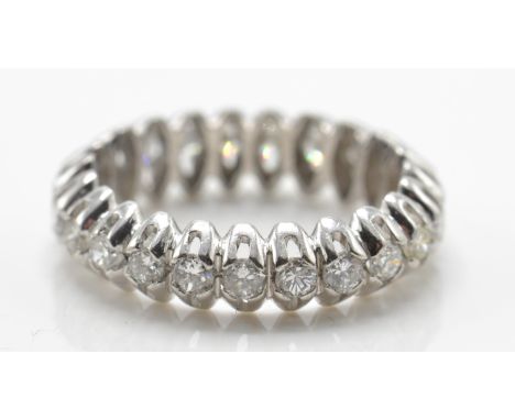 A white gold and diamond full eternity ring. The ring having 22 round brilliant cut diamonds in a pierced scalloped setting. 