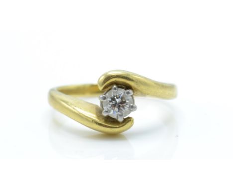 An 18ct gold and diamond solitaire crossover ring. The ring set with a round brilliant cut diamonds of approx 0.25cts. Un mar