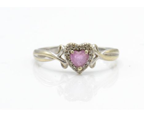 A hallmarked 9ct white gold pink stone and diamond ring. The ring having a central heart cut pink stone surrounded by a halo 