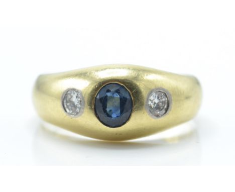 A 14ct / 585 gold sapphire and diamond dome ring. The ring set with a central oval mixed cut sapphire flanked by 2 brilliant 