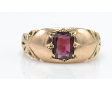An Edwardian Chester hallmarked 9ct gold band ring set with a mixed cut garnet in a domed setting. Hallmarked Chester 1906. T