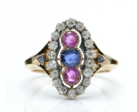 An 18ct gold ruby diamond and sapphire ring. The ring set with a central sapphire flanked by two rubies and surrounded by a h