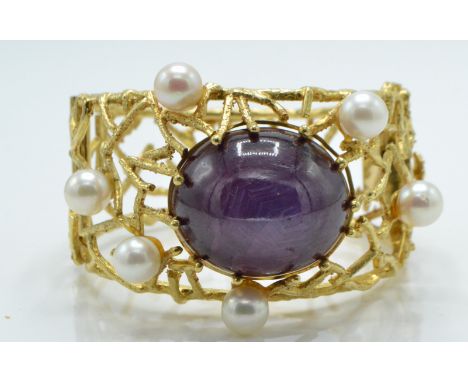 A large 18ct gold ruby and pearl wirework bracelet - bangle. The wirework in the form of branches set with a large ruby caboc