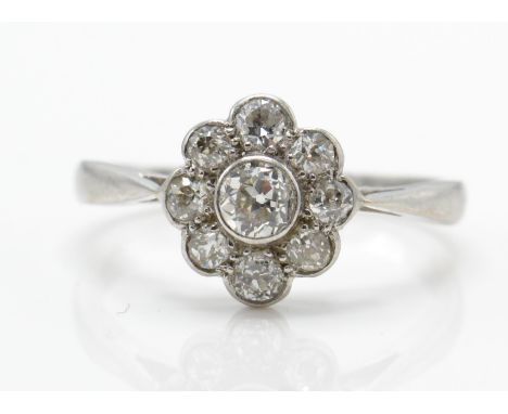 An 18ct white gold and diamond cluster ring. The ring set with a brilliant round cut diamond surrounded by eight smaller roun