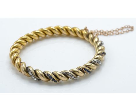 A French 18ct gold sapphire and diamond bangle / bracelet. The bangle with rope twist design having alternating crescents of 