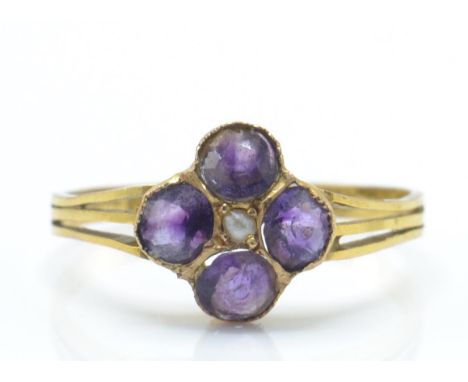 A hallmarked antique amethyst and pearl cluster ring. The ring being set with four mixed cut amethyst&nbsp; surrounding a cen