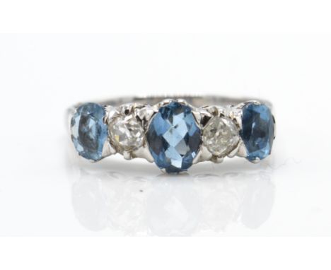 An 18ct white gold aquamarine and diamond five stone ring. The ring set with 3 graduating oval mix cut aquamarines having old