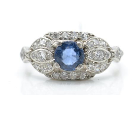 An 18ct white gold diamond and sapphire dome ring. The ring set with a round mix cut blue sapphire surrounded by pierced pave