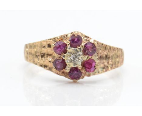 A 1970's hallmarked 9ct gold ruby and diamond ring. The ring having a central illusion set diamond surrounded by round cut ru