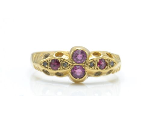 An Edwardian hallmarked 18ct gold ruby and diamond ring. The ring set with mix cut rubies and rose cut diamond accents within