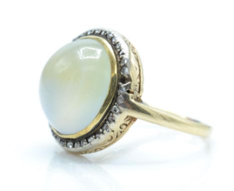 A 14ct gold diamond and bi-coloured quartz cabochon ring. The ring set with a quartz exhibiting a pale citrine and amethyst c