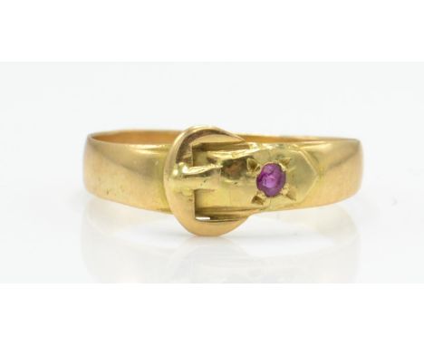 A hallmarked Victorian 18ct gold and ruby buckle ring. The ring being set with a round mix cut ruby within buckle motif to pl