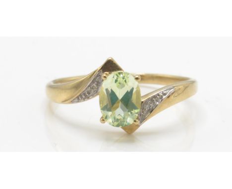 A 9ct quartz and diamond ring. The ring set with a central oval mixed cut stone flanked by illusion set diamond shoulders. Ma