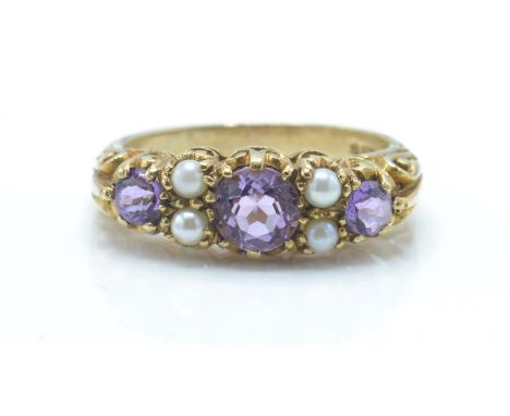 A hallmarked 9ct gold amethyst and pearl ring. The ring set with 3 graduated round cut mixed amethyst flanked by pearls in a 