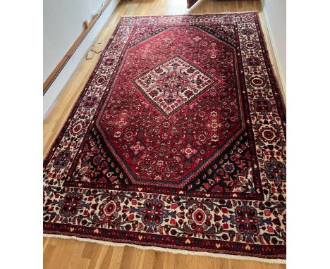 A red ground hand knotted wool carpet (3.45 m x 2.10 m)