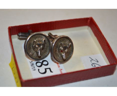 A pair of white metal hunting cuff-links with foxes heads and red stones for eyes