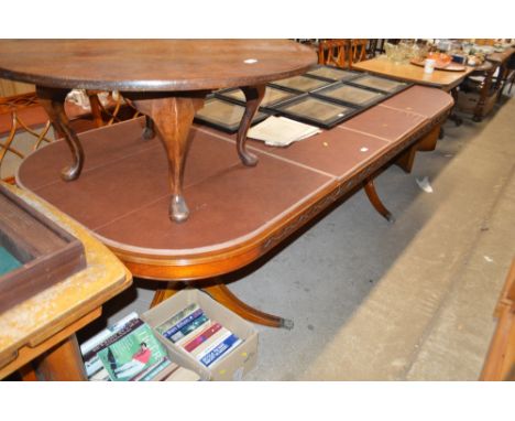 A large reproduction yew wood twin pillar extending dining table with two extra leaves; with a set of ten matching dining cha