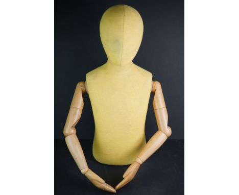 A vintage half torso Childs mannequin with articulated wooden arms. 