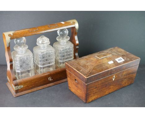 An antique wooden sarcophagus tea caddy together with a three decanter tantalus. 