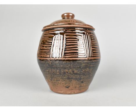 A Glazed Terracotta Studio Pottery Lidded Jar with Sgraffito Decoration After Bernard Leach