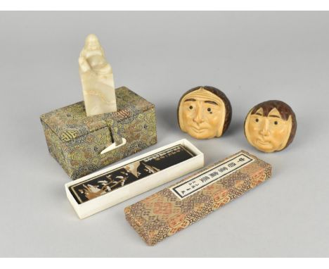 A Boxed Chinese Carved Soapstone Seal, a Japanese Ingot and Two Chinese Nut Mask Carvings