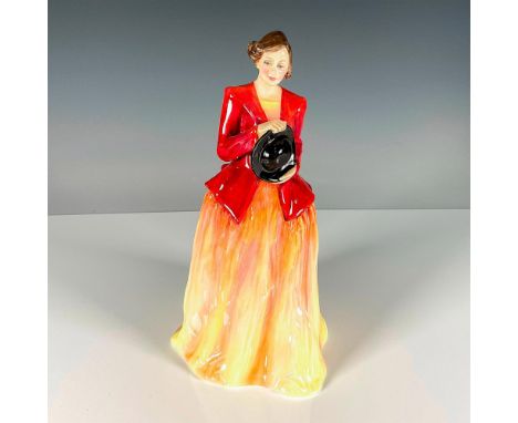 This prototype is glossy bone china depicting a woman in a yellow and orange dress with a red overcoat holding a black hat. R