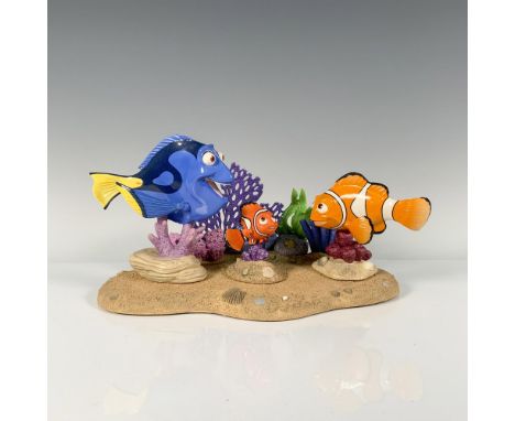 Nemo, Marlin, and Dory joyfully swimming amidst a vibrant coral reef base, providing a display of underwater magic. Walt Disn