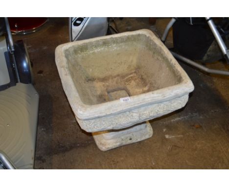 A concrete planter on stand