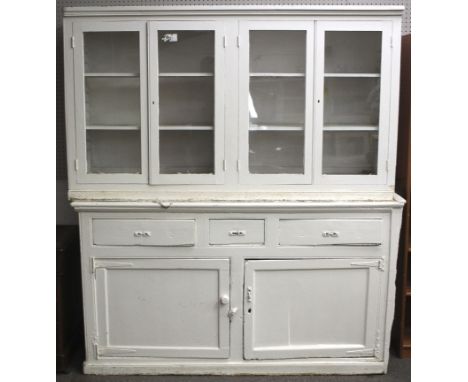 A vintage wooden dresser. Painted white, the upper section with a pair of cabinets with glazed doors, containing two adjustab
