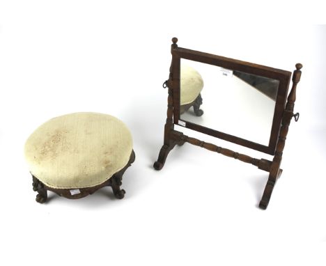 An early 20th century mahogany footstool and a swing mirror. The first with cream upholstery, diameter 34cm, the second with 