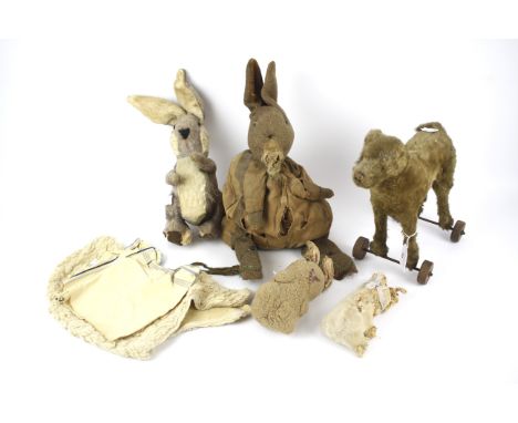 An assortment of vintage soft toys. To include a push along dog, bunnies, etc