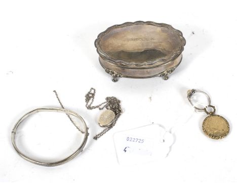 An assortment of silver. Comprising a velvet lined lidded box of oval form, a locket and chain, pendant, ring and a hinge ban