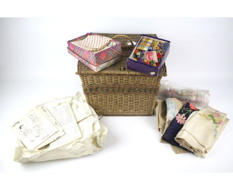 A vintage wicker sewing basket. Opening to reveal an assortment of related items, including pins, fabric and patterns