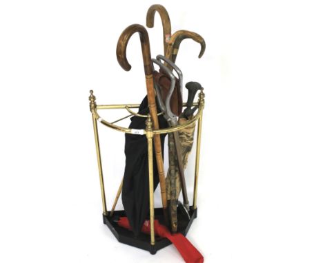 An early 20th century brass stick stand together with a selection of sticks and umbrellas. To include an umbrella with 18ct g