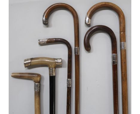 Six various silver-mounted walking sticks, including an example with ebonised shaft, horn handle and London mounts, a further