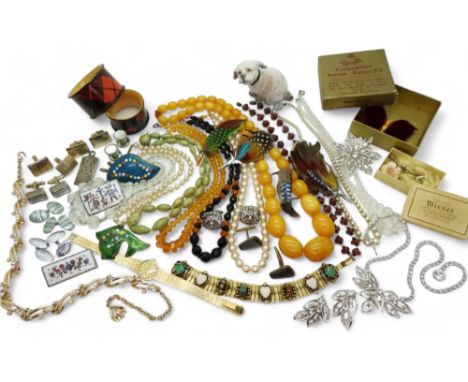 A collection of vintage costume jewellery to include beads, Folk Art enamel brooches, Scottish feather brooches, retro cuffli