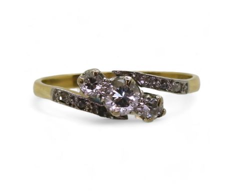 An 18ct vintage three stone ring the shoulders set with diamond accents, the three main diamonds are estimated at 0.25cts, fi