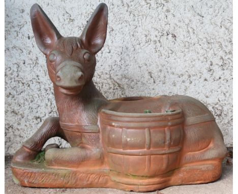 A contemporary decorative stoneware garden planter modelled as a donkey at rest with saddlebags acting as planters, 63cm high