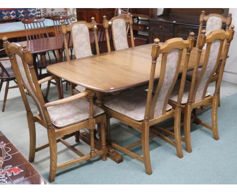 A 20th century Ercol elm and beech extending dining table and six chairs, table on trestle supports joined by stretchers, 74c