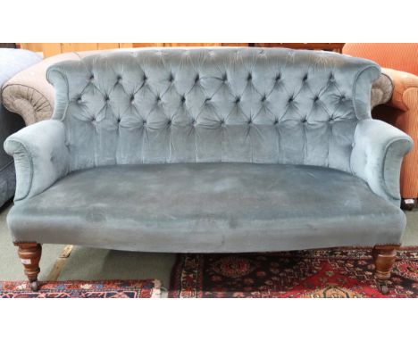 A Victorian blue buttonback upholstered two seater settee on turned front supports terminating in ceramic casters, 77cm high 