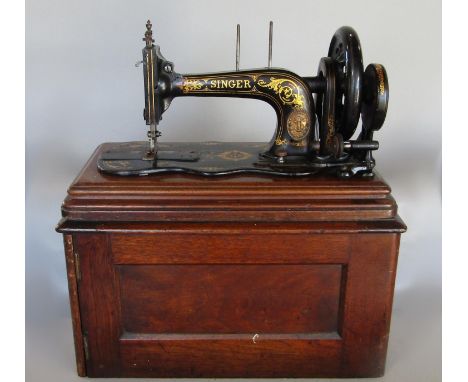 A vintage Singer sewing machine and its mahogany case 