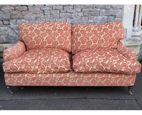 A contemporary Howard style two/three seat sofa labelled George Smith Ltd with shaped outline, repeating floral patterned uph