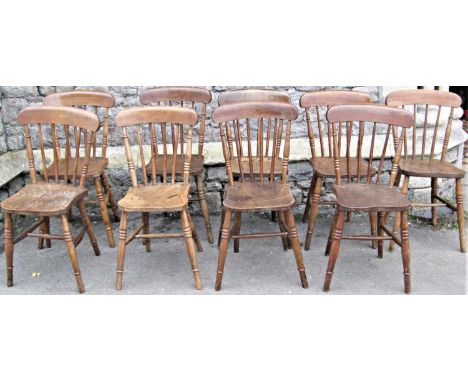 A harlequin set of ten stained elm and ashwood Windsor stick back kitchen chairs with splayed ring turned and tapered support