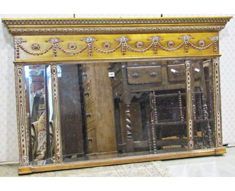 A Regency style overmantle mirror with triple bevelled edge mirror plates within a gilt moulded frame with classical trailing
