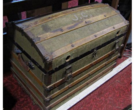 A canvas and wooden bound domed trunk containing hunting prints, a pair of vintage riding boots, leather rifle bag, two carri