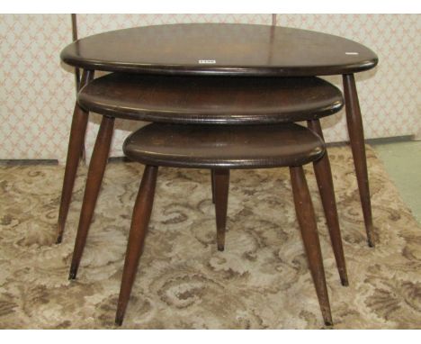 A nest of three Ercol dark stained elm and beechwood "pebble" occasional tables (ring marks and further stains to outer table