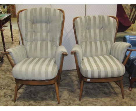 An Ercol Windsor range hoop and stickback three piece suite with stained beechwood frames, comprising two seat sofa and two a